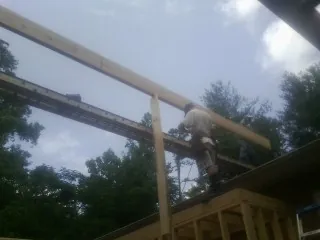 Carpenter setting a ridge beam over a new addition frame — Ice Dam Removal by Roofing Brothers in Woodbury Heights