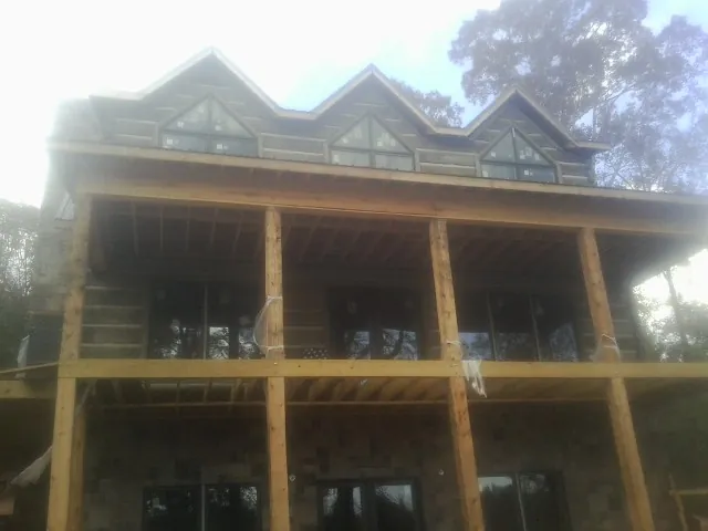 Dormers and porch framing on a large log home under construction — Roof Coating work by our crew in Woodbury Heights