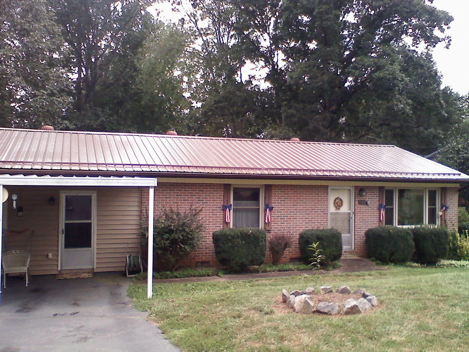 Bronze metal roof and carport on a brick ranch home — Roof Repair work by our crew in Woodbury Heights